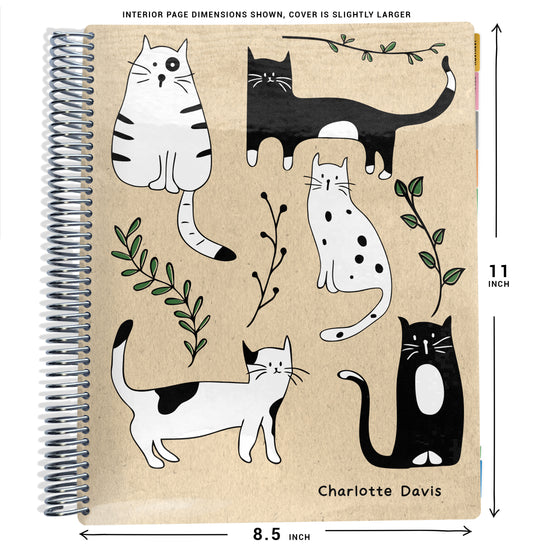 black and white cats with green leaves on beige background on planner Notebook with spiral binding and size dimensions labeled on a white background