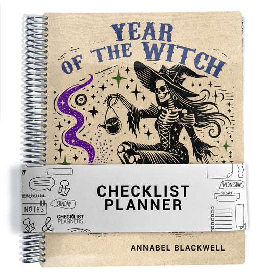 The image is a spiral-bound notebook with a black and white illustration of a skeleton wearing a witch's hat, surrounded by stars and a purple wave. The notebook has a black and white title that reads "YEAR OF THE WITCH" and "CHECKLIST PLANNER" printed on it.